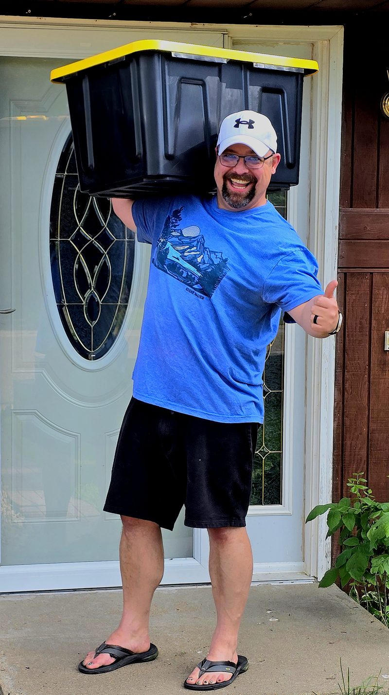 Tori of TNT Rental carrying a black and yellow moving tote on his shoulder